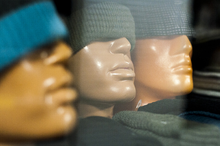 mannequin head with a winter hat in the shop windowの写真素材