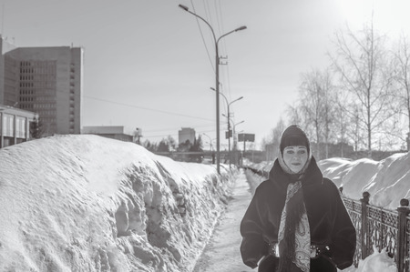Portrait of an adult woman in the park winter sunny day blurred background behind two lanternの写真素材