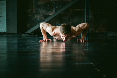 Young sexy male bodybuilder athlete with a bare torso. portrait of a studio of a light-skinned...