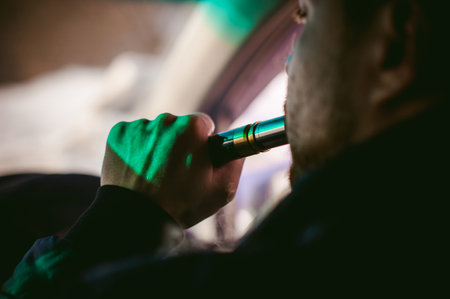 young vaper man with beard vaping mechanical mod. Guy smokes an electronic cigarette by blowing a...