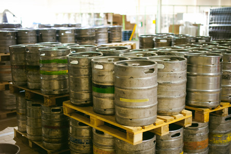 beer kegs. many metal beer keg stand in rows in a warehouseの写真素材