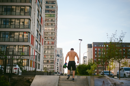Handsome sexy male bodybuilder athlete man with naked torso, running in morning, outdoors. Healthy lifestyle concept.の写真素材