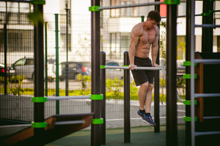 Handsome sexy male bodybuilder athlete man doing crossfit workout in athletic facilities on sunny...