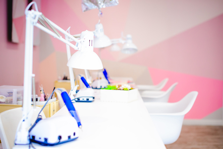 Workplace in a bright manicure salon. Working table of the master of nail service, chairs and lampsの写真素材