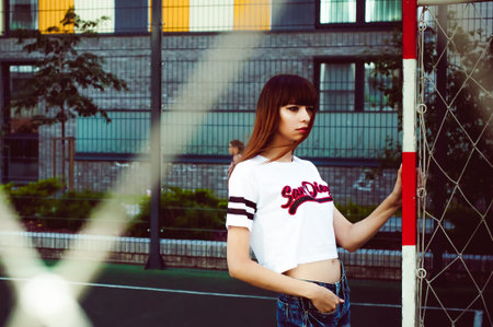 portrait attractive women in sports white T-shirt Posing on football fieldの写真素材