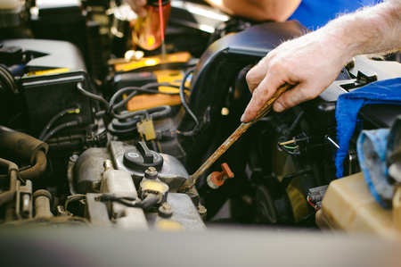 hands of an auto mechanic close-up. servicing and caring for a car engineの写真素材