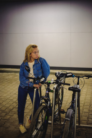 young beautiful woman in jeans clothes in parking of shopping center. portrait of a girl with...