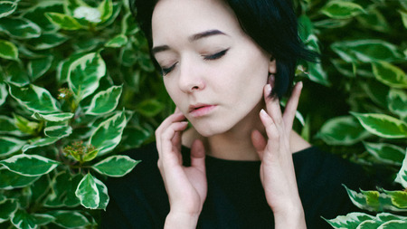 young woman with beautiful feet dressed in black dress, against a backdrop of urban landscapes bush. Street fashion.の写真素材
