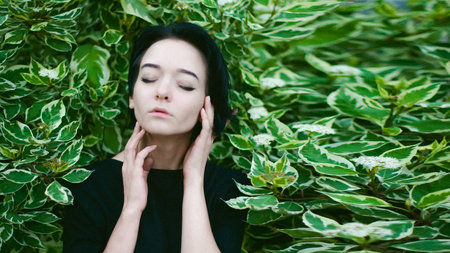 young woman with beautiful feet dressed in black dress, against a backdrop of urban landscapes bush. Street fashion.の写真素材