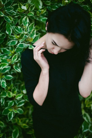 young woman with beautiful feet dressed in black dress, against a backdrop of urban landscapes bush. Street fashion.の写真素材