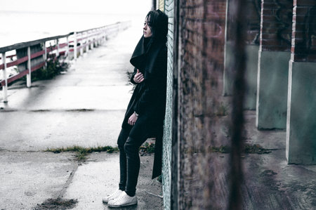 fashionable portrait of a young brunette woman in black clothes, jeans T-shirt, coat and sunglasses,...