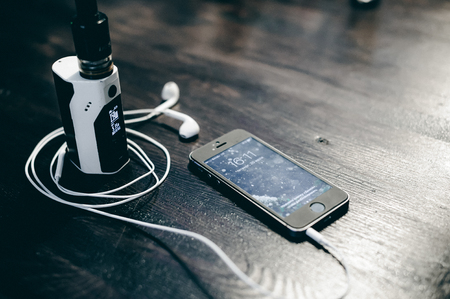 smartphone and electronic cigarette on a wooden tableの写真素材