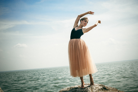 athletic woman engaged in stretching, warm summer day, exercise in the open airの写真素材