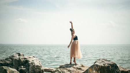 athletic woman engaged in stretching, warm summer day, exercise in the open airの写真素材
