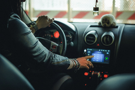 brunette woman in black fashionable leather clothes on style, auto lady. driving a carの写真素材