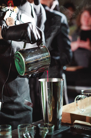 championship among coffee houses, members of teams show barista's skill, prepare drinks, teamwork. pours drink into glassesの写真素材