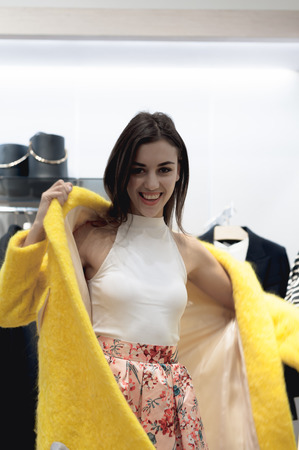 young beautiful emotional modern woman walks through the shopping center, looks at fashion things in clothing storesの写真素材