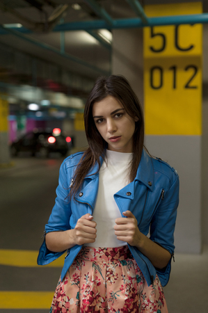 Fashionable beautiful young brunette woman standing on background of climb to parking floor. model posingの写真素材