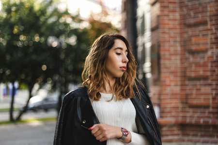 portrait of a young beautiful woman on street, model posing, women's urban street fashion, warm colorsの写真素材