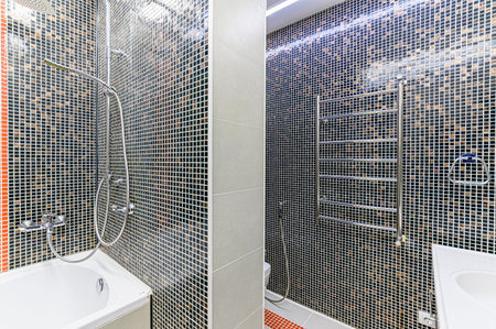 Interior of a modern bathroom with black tiles and shower. Nobody inside