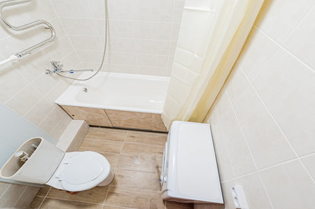 White toilet bowl and toilet paper in a modern bathroom. Nobody inside