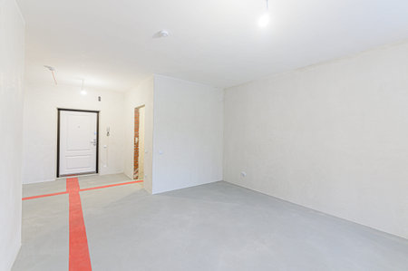 Interior of empty room with white walls and gray floor. Nobody inside
