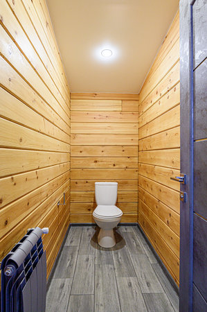 Interior of a modern bathroom with wooden walls and a toilet bowlの写真素材