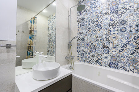 Interior of a modern bathroom with ceramic tile wall and white sink