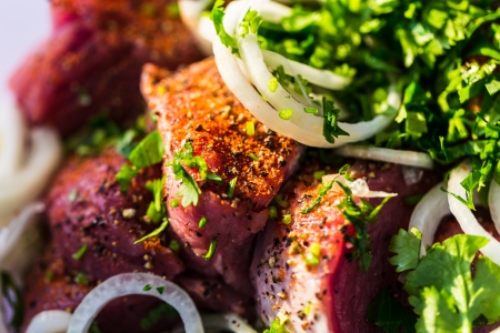 Raw pork meat with onions spices and herbsの写真素材