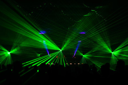 bright laser show in the crowd of merry menの写真素材