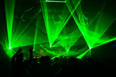 bright laser show in the crowd of merry menの写真素材