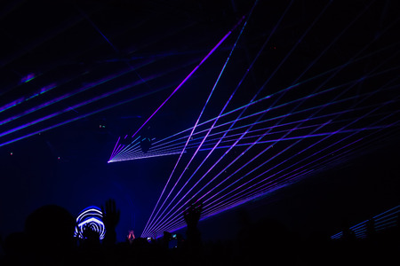 bright laser show in the crowd of merry menの写真素材