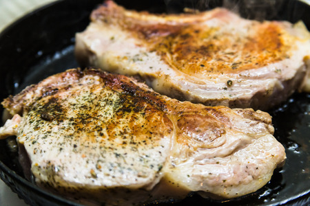 pork meat with rosemary on a cast iron skilletの写真素材