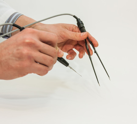 doctor's hand wich holding electrocautery and surgical tweezers and remove the mole from the back of the patient's. Radio wave electrocoagulation remove methodの写真素材