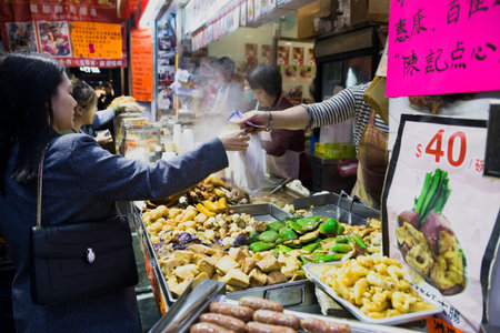 Tasty fried food on a street kitchen in Asia. Fresh vegetables, meat and fish. Hong Kong, China, march 04, 2017のeditorial素材