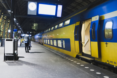 Netherlands, The Netherlands, Amsterdam, November 5, 2015 Dutch yellow double decker train is leaving a stationのeditorial素材