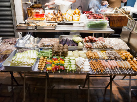 Tasty fried food on a street kitchen in Asia. Fresh vegetables, meat and fish. Hong Kong, Chinaの写真素材