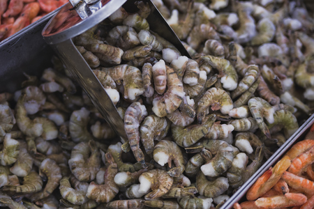 fresh raw shrimps in a bowl on a wooden tableの写真素材