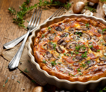 Tart with brown mushrooms on a wooden rustic tableの写真素材