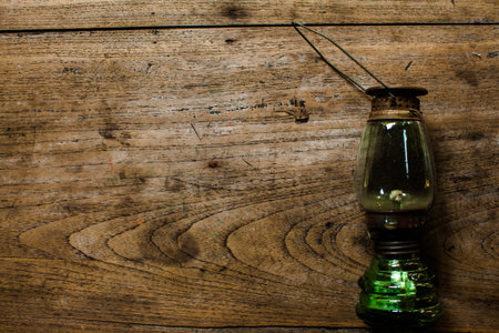 Oil lamp on wooden table,vintage color style, old rusty kerosene lamp .