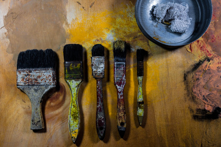 old grungy paint brushes on wood floor .の写真素材