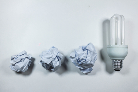 idea concept with crumpled  paper and light bulb on white background.の写真素材