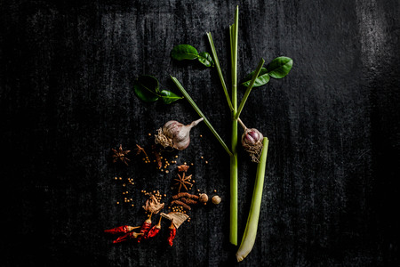 Herbs and spices around empty cutting board on dark stone background,cooking concept,Thailand.の写真素材