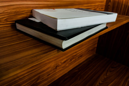two books on a wooden table, notebook on a wooden table.