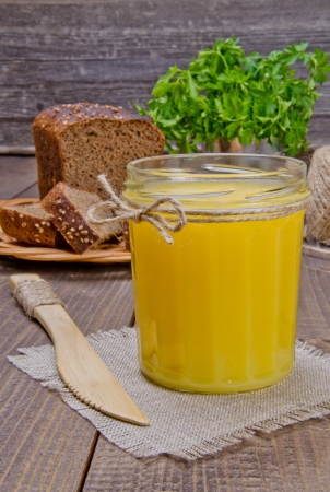 A glass jar with a yellow substance on a wooden surfaceの写真素材