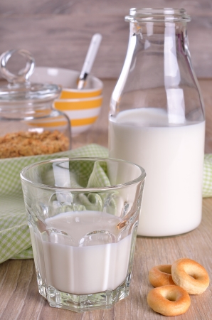Glass and bottle of milk on a wooden surfaceの写真素材