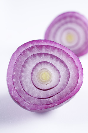 Half cut red onion on white background の写真素材
