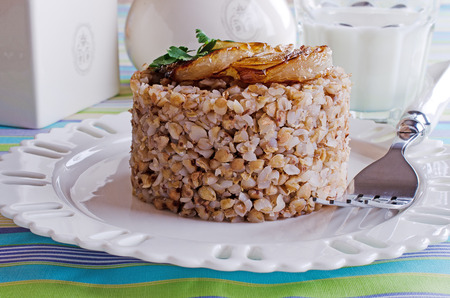 buckwheat porridge with fried onions, lying on a white plate の写真素材