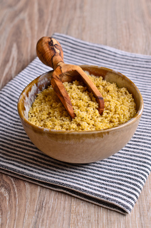 Fine pasta in the shape of a star lies in a wooden scoop on striped napkinの写真素材