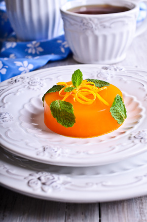 Jelly orange with green leaves on a beautiful mint plateの写真素材